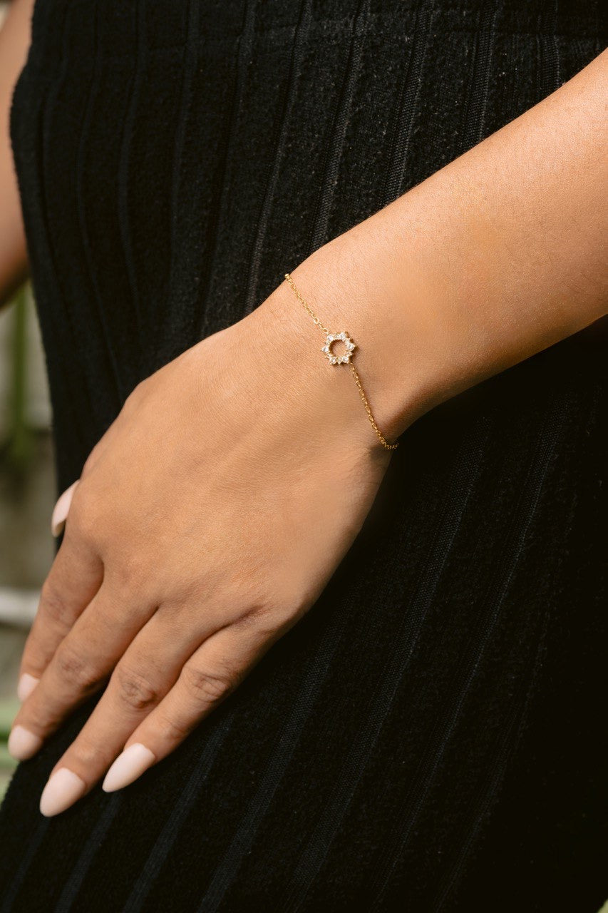Gold bracelet on a person's wrist with a blurred background