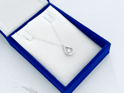 Silver necklace with a teardrop pendant in a blue jewelry box on a white background